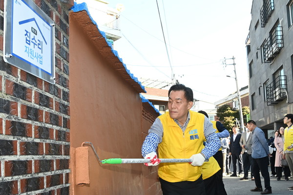 사진) 지난해 10월 이재준 수원시장이 1호 새빛하우스(집수리지원사업)의 담장을 칠하고 있다.ⓒ경기타임스