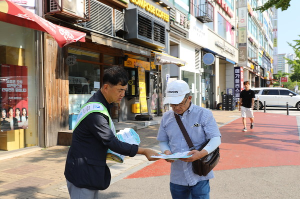 사진)시민에게 안전한 개인형이동장치 이용 방법을 홍보하고 있다.ⓒ경기타임스