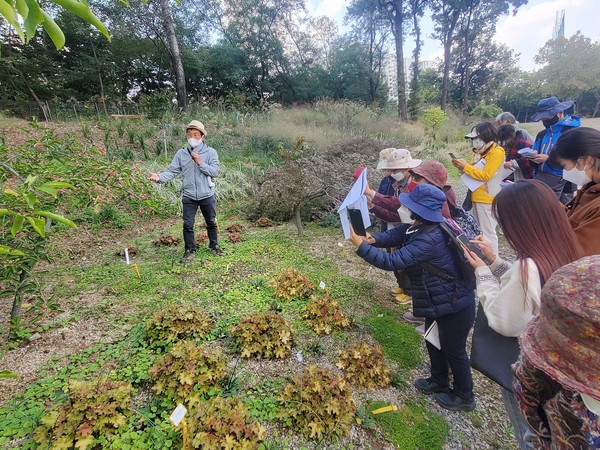 사진) ‘수원수목원 서포터즈’ 단원들이 수목원 양묘장에 있는 식물을 관찰하고 있다. ⓒ경기타임스