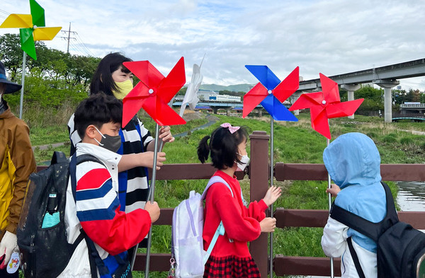 사진) 유림동 행복마을관리소 지킴이들과 성산초등학교 1~2학년 아이들이 직접 등하굣길 꾸미기에 나섰다ⓒ경기타임스