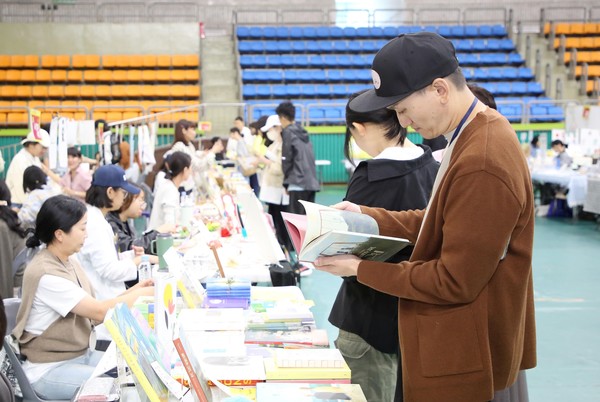 지난해 10월 12일 광명시민체육관에서 열린 '2024년 광명아트북페어'에서 시민들이 책을 읽고 있다.ⓒ경기타임스