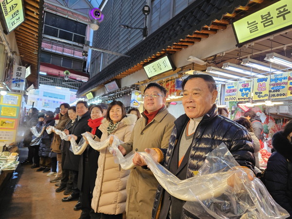 김현수 수원시 제1부시장(오른쪽 2번째), 이재식 수원시의회 의장 등이 시민들과 함께 가래떡 나눔 행사에 참여하고 있다. ⓒ경기타임스