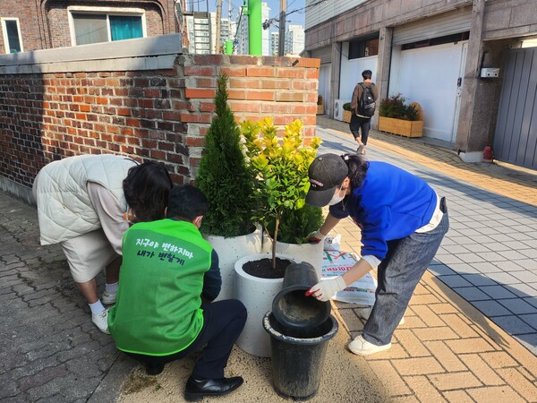 주민실천단이 사업지 내 골목에 화분을 설치하고 있다.ⓒ경기타임스