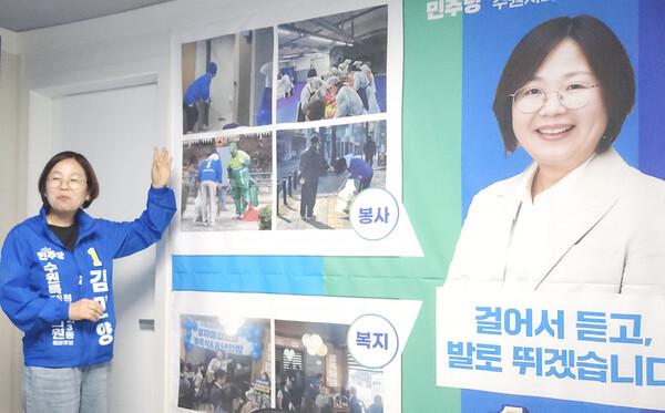 김민양 더불어민주당 수원시의원 후보(다 선거구·정자1·2·3동)가 쓰레기봉투와 집게를 들고 정자동 골목을 돌며 환경 정화 활동하고 있는 모습을 설명하고 있다.ⓒ경기타임스